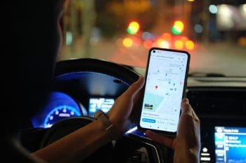 A Car Driver Reading A Map On His Phone