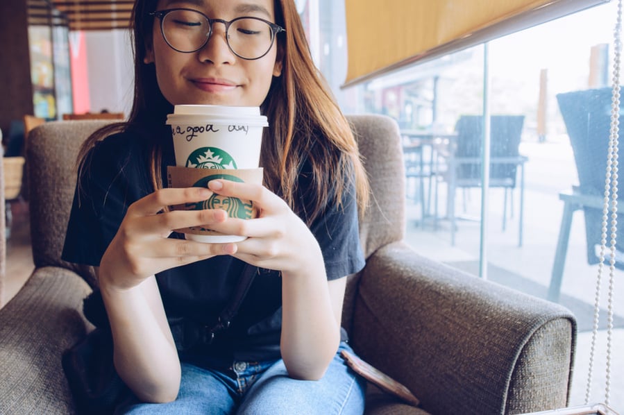 Happy Girl Holding Paper Cup Of Starbucks Coffee