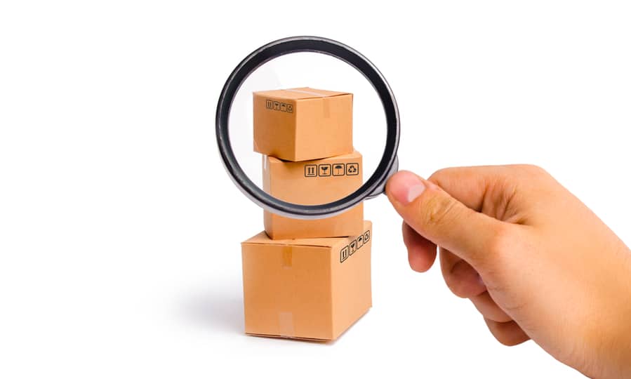 Magnifying Glass Is Looking At The Cardboard Boxes On A White Background.