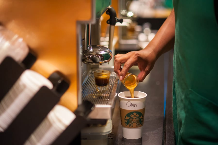 Starbucks Coffee Barista Standing In Front Of Machine