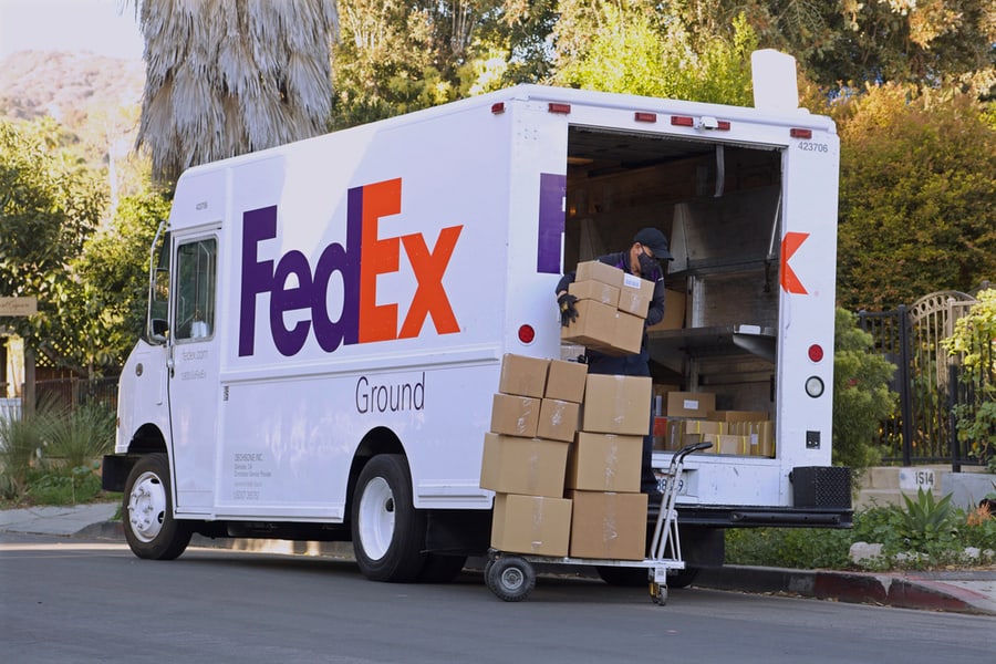 Fedex Driver Loading Boxes Into Delivery Truck