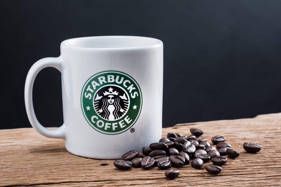 Studio Still Life Photography Of Starbucks Coffee Mug With Coffee Bean On Old Wood : Starbucks Is Global Brand Of Coffee Drink And Very Popular In Thailand