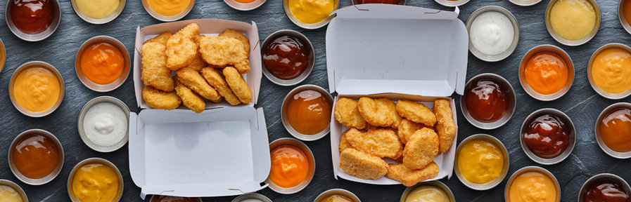 Two Boxes Of Fast Food Fried Chicken Nuggets With Different Dipping Sauces