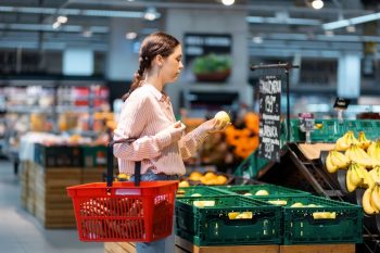Woman Using A Shopping Basket At A Supermarket