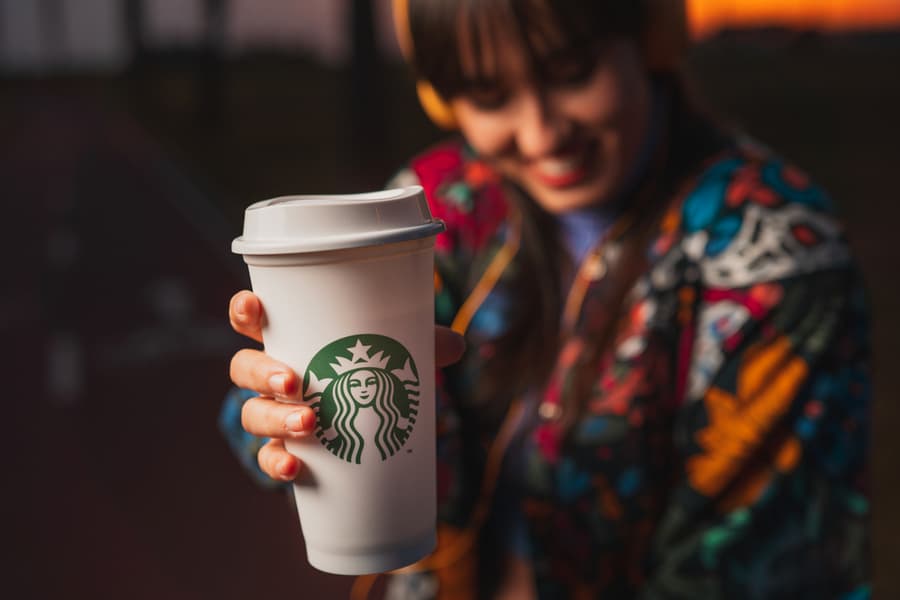 Woman With Yellow Headphones And Drinking Hot Starbucks Coffee