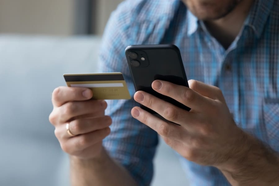 Young Man Holding Cellphone And Credit Card