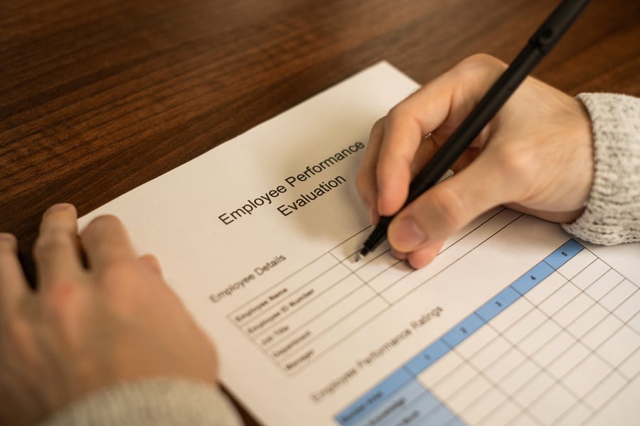 A Coach Filling Out An Employee Performance Evaluation Form