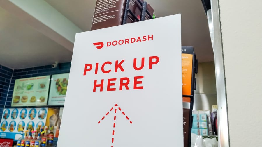 A Doordash Placard Sign On A Counter Of A Restaurant