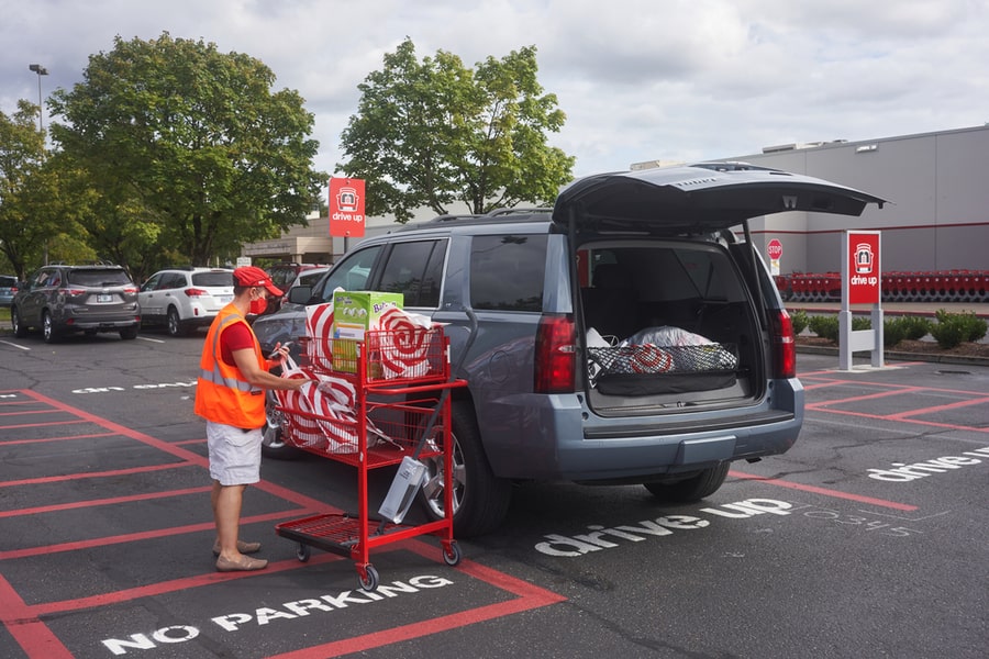 A Target Store Employee Brings Bagged Items Out To A Customer's Car Parking Area