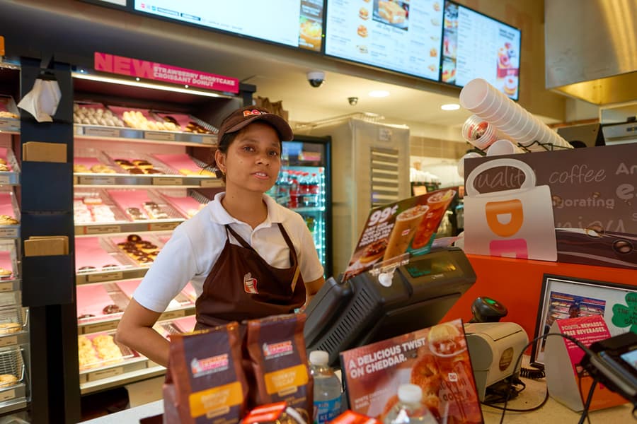 A Worker At Dunkin Donuts In Simple Dress Code