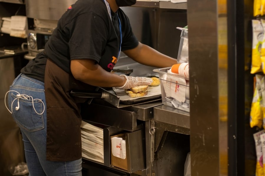 A Worker Is Seen Making A Sandwich In The Kitchen Of A Dunkin' Donuts