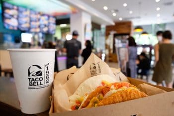 Box Set Of Tasty Taco, Nachos, And Cup Of Drink Served In Retail Background Of Taco Bell Restaurant.