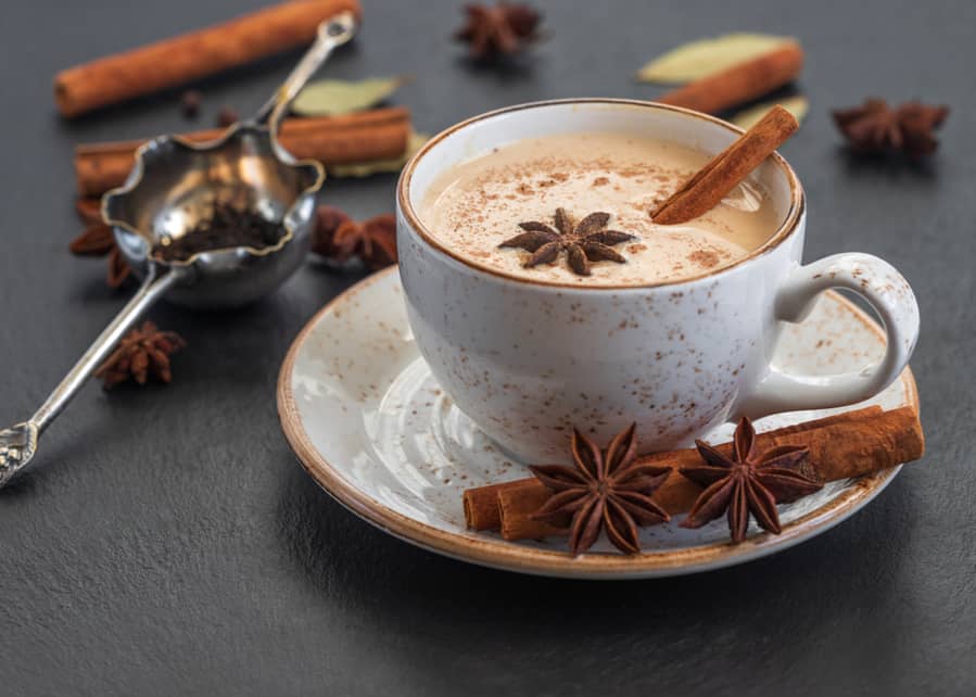 Hot Drink With Milk And Spices On Dark Stone