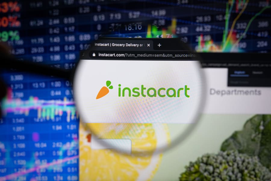 Instacart Company Logo On A Website With Blurry Stock Market