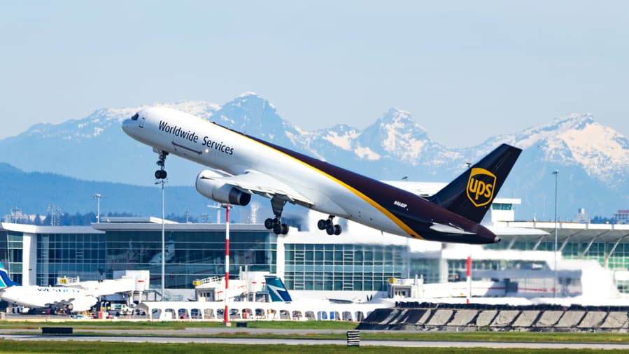 Ups Airlines Boeing 757 Taking Off From Vancouver Intl. Airport With Snow-Covered Mountains In The Background.