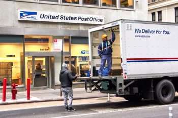 Usps Postman On A Mail Delivery Truck In New York.