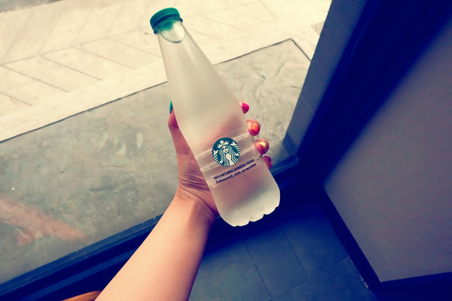 Woman Holding Bottle Of Water Being Sold At Starbucks