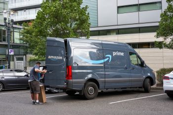A Driver Unloads An Amazon Prime Delivery Van