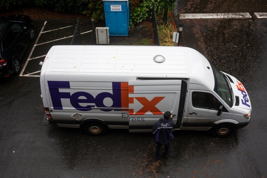A Fedex Driver Opens The Sliding Door On His Delivery Van