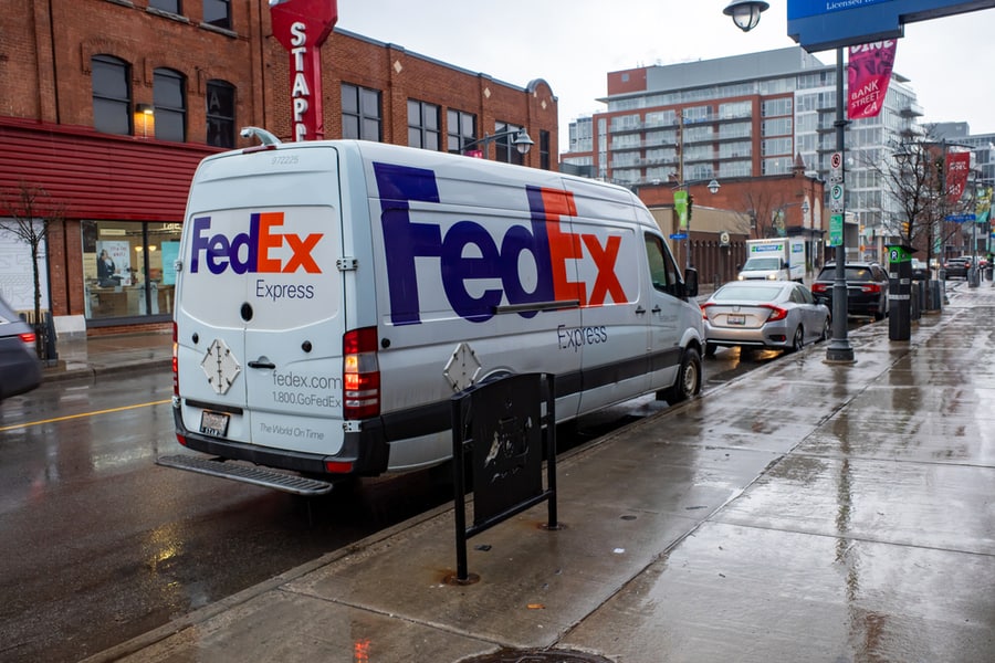 A Fedex Express Delivery Van Is Stopped On The Side Of A Street