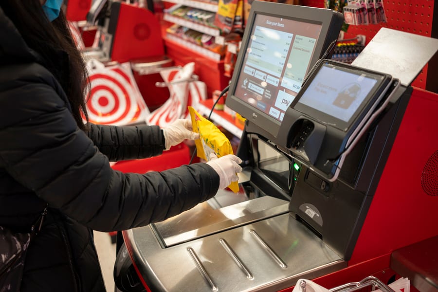 A Shopper In Nitrile Gloves Scans A Bag Of Ricola Cough Drops At The Self-Checkout Lane