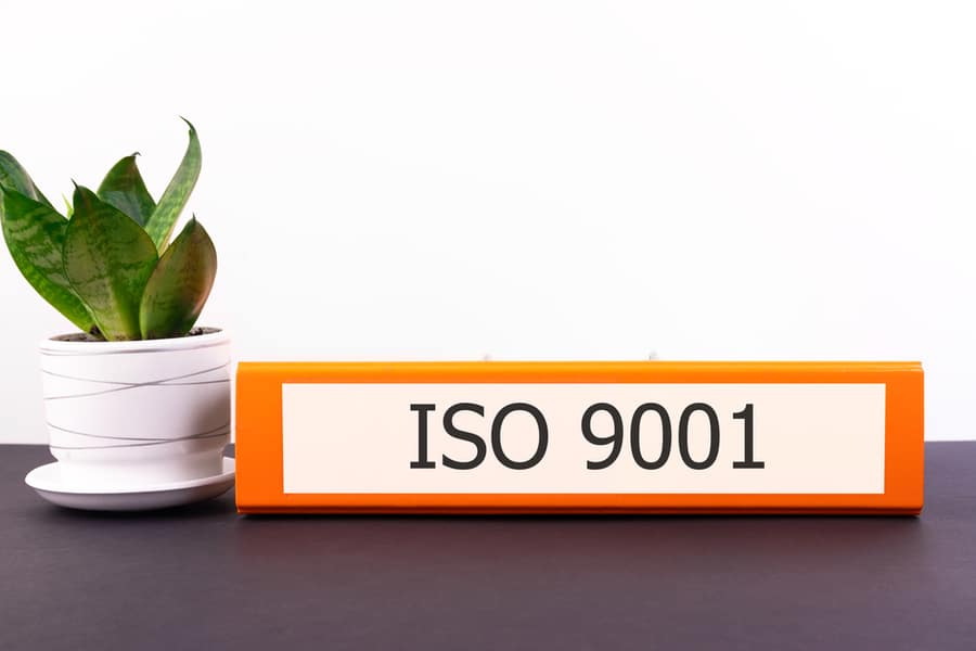 Close-Up Of An Office Desk With Iso 9001 Folder