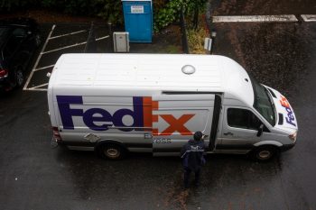 Fedex Driver Opens The Sliding Door On His Delivery Van On A Rainy Day