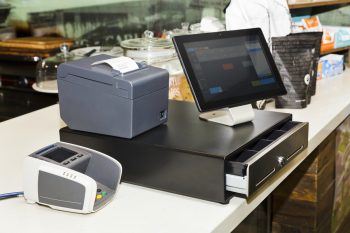Pos Terminal On A Cashbox At A Counter In Regular Retail Coffee Shop