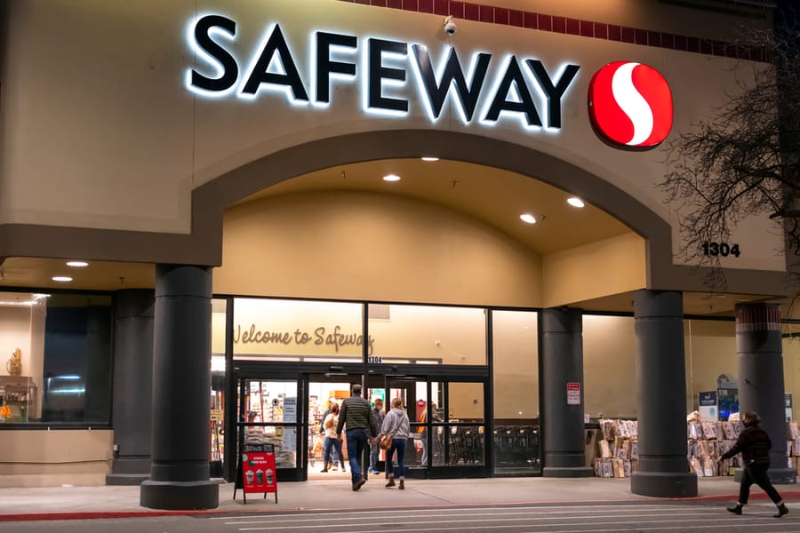 Shoppers Enter An Illuminated Safeway Supermarket Grocery Store At Night