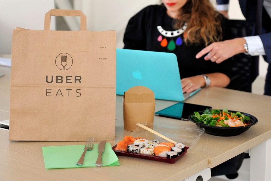 Women Working On Laptop Order Food From Uber Eats At Work